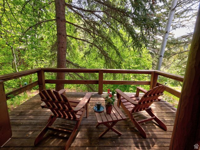 Wooden deck off dining area and bedroom, with serene, wooded view | Image 19