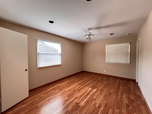 Empty room featuring wood finished floors and a ceiling fan | Image 7