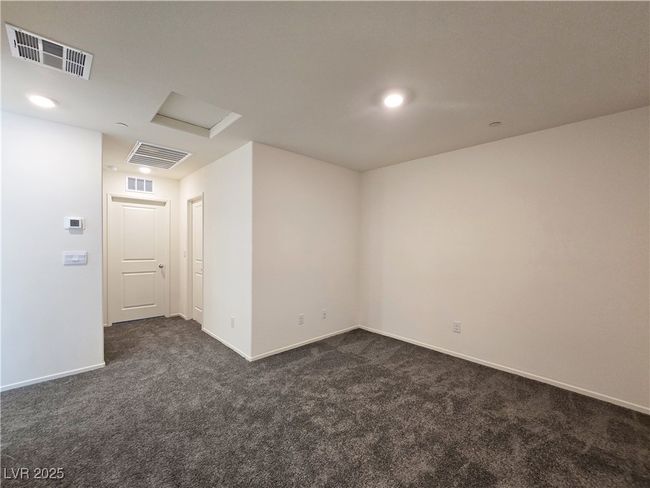 Empty room with dark carpet, attic access, baseboards, and recessed lighting | Image 15