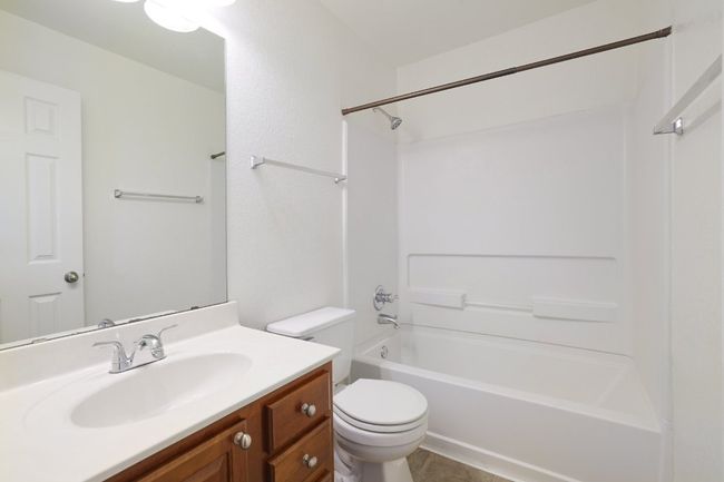 Bathroom featuring toilet, tile patterned flooring, vanity, and shower / bathing tub combination | Image 28