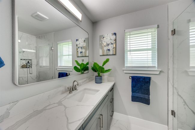 Full bathroom with a marble finish shower, vanity, and marble look tile flooring | Image 22