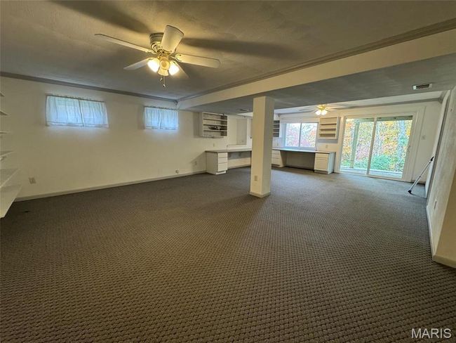 Basement with dark colored carpet and ceiling fan | Image 40