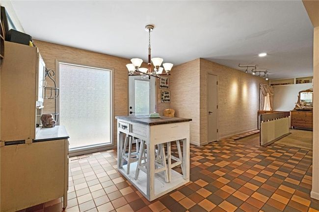 Tiled dining area featuring a chandelier and rail lighting | Image 11
