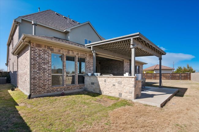 Back of property featuring a patio, brick siding, roof with shingles, and fence | Image 21