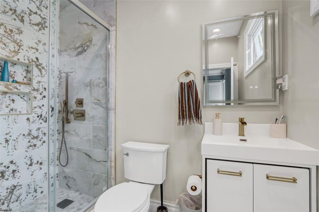 Bathroom featuring toilet, vanity, and a shower stall | Image 21