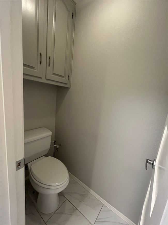 Bathroom with marble look tiles and toilet | Image 26