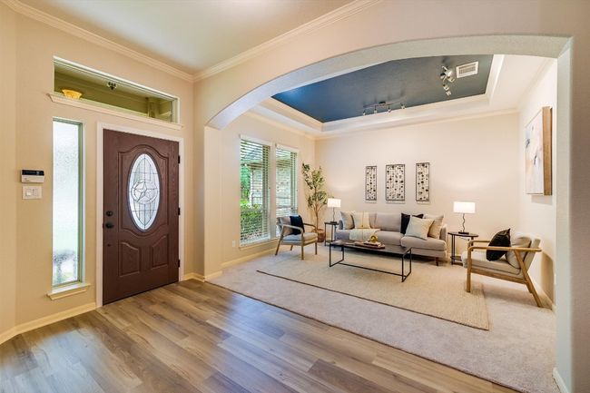Foyer entrance featuring arched walkways, crown molding, wood finished floors, and a raised ceiling | Image 8