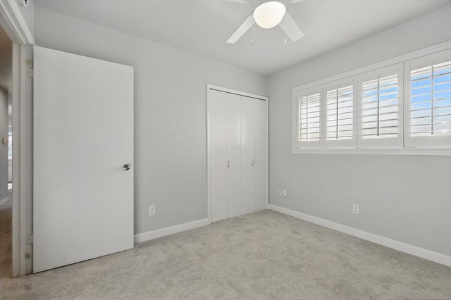 Unfurnished bedroom with a closet, carpet flooring, baseboards, and multiple windows | Image 28