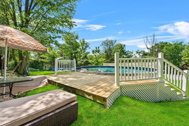 Wooden deck featuring an outdoor pool and a yard | Image 31