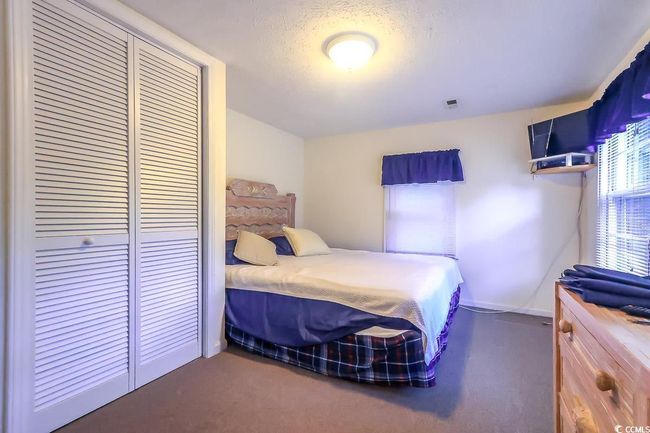 Bedroom with a closet, dark carpet, and a textured ceiling | Image 9