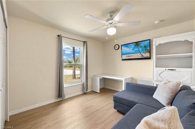 Living area with baseboards, ceiling fan, and light wood-style floors | Image 17