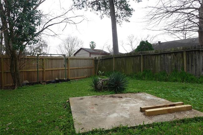 Tranquil backyard with lush greenery, mature trees, and a private fence—perfect for relaxation and outdoor activities. | Image 27