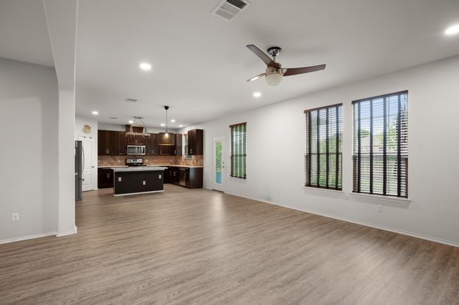 Unfurnished living room with ceiling fan, visible vents, baseboards, light wood finished floors, and recessed lighting | Image 19