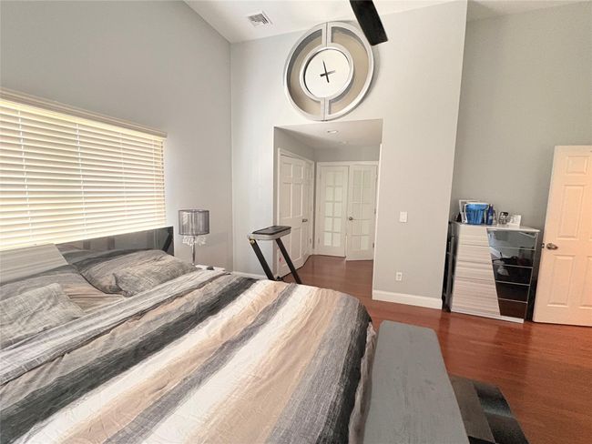 Bedroom with a towering ceiling, wood finished floors, and baseboards | Image 10