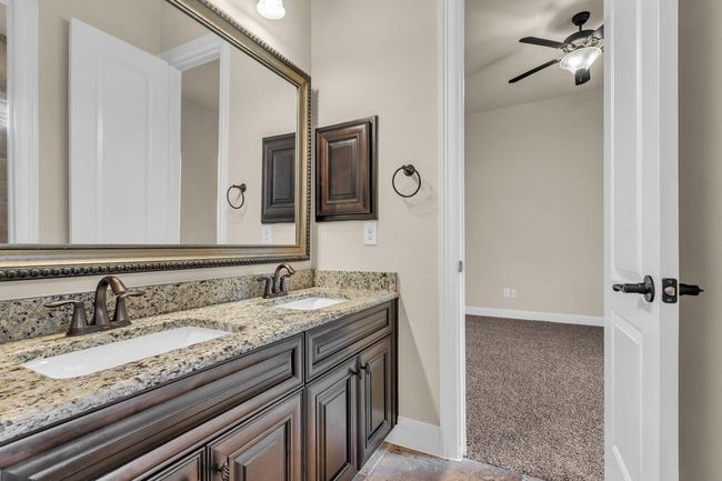 The connecting bathroom features dual sinks, a spacious vanity, and a private tub/shower area—combining convenience with privacy in a thoughtfully designed space. | Image 25