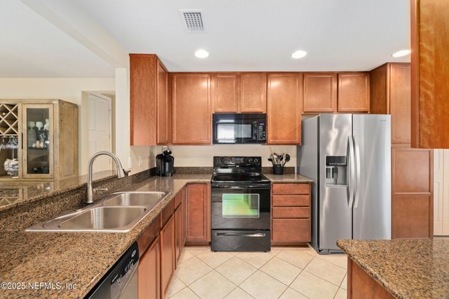 This large kitchen offers ample counter space and a cozy dine-in area for everyday living. | Image 5