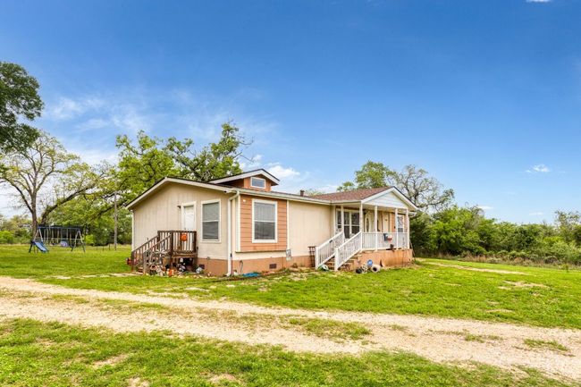 Side view of home which features covered front porch, and a back entrance leading into laundry room/breakfast area | Image 27