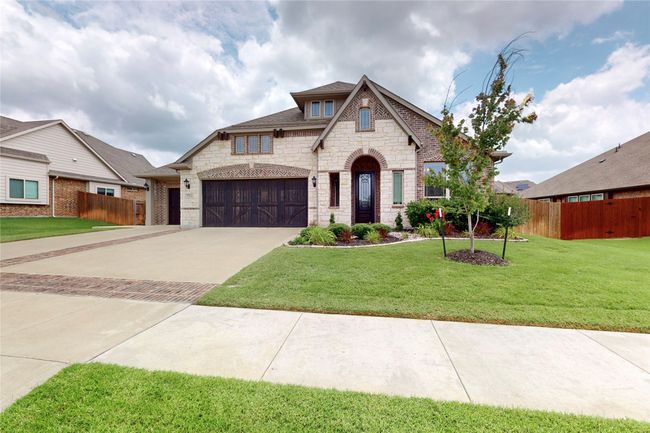 French country home with stone siding and concrete driveway | Image 4