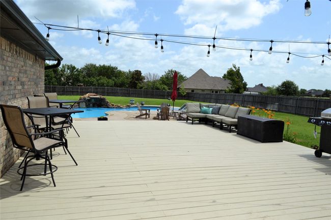 Wooden deck featuring an outdoor hangout area, a fenced backyard, and a grill | Image 32