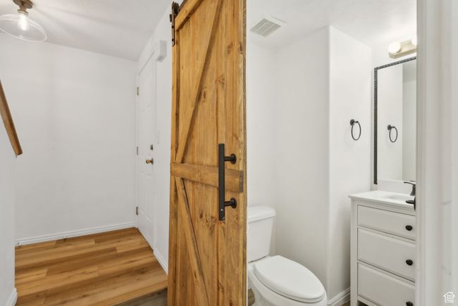 Bathroom with vanity, toilet, wood finished floors, and baseboards | Image 9