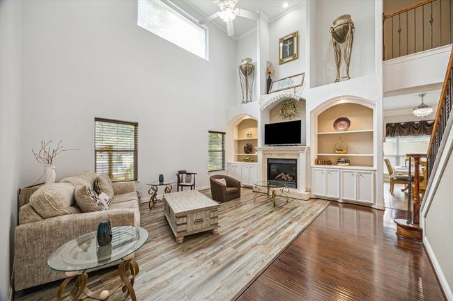 20ft ceilings in grand living room overlook the stairway and kitchen. Gas log fireplace w remote is the focal point. living room overlooks private and fully fenced backyard. | Image 8