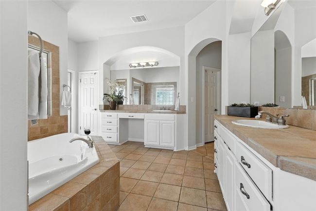 Bathroom featuring two vanities, a bath, and tile patterned flooring | Image 22