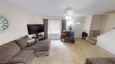 Living room with light carpet and ceiling fan | Image 2