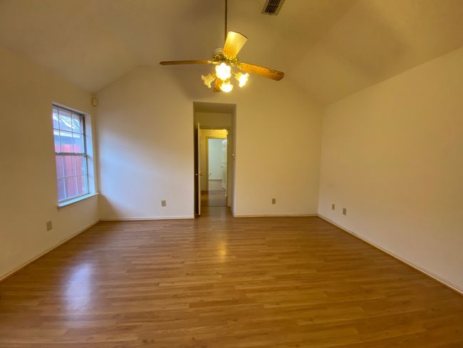 Spare room featuring ceiling fan, light wood-type flooring, and lofted ceiling | Image 17