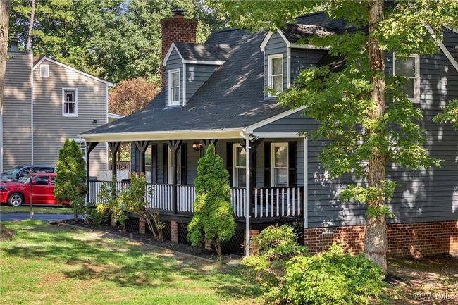 Cape cod home featuring covered porch, a chimney, a front lawn, and a shingled roof | Image 4
