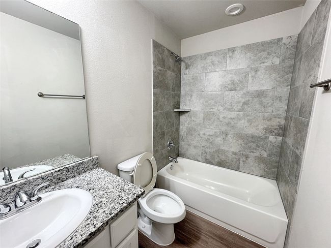 Bathroom with vanity, shower / washtub combination, and wood finished floors | Image 13