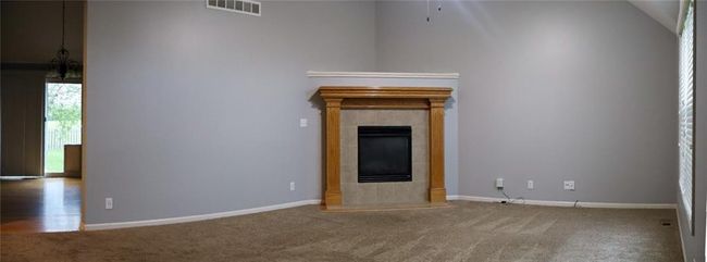 Unfurnished living room featuring carpet flooring and a tile fireplace | Image 5