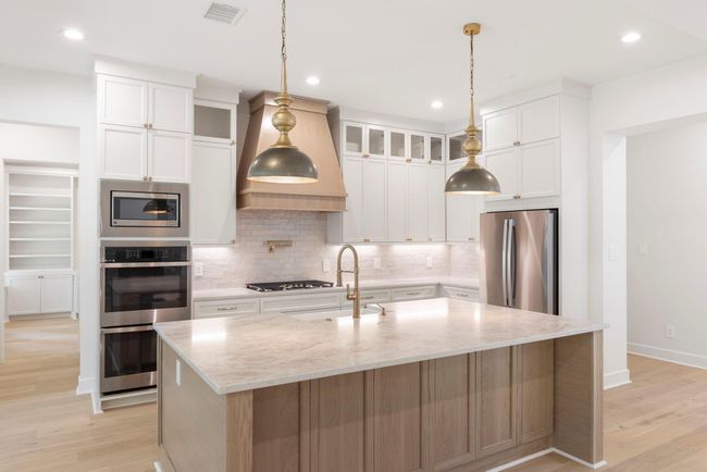 Beautiful and timeless custom designed kitchen with stainless steel appliances and a gas cooktop. | Image 8