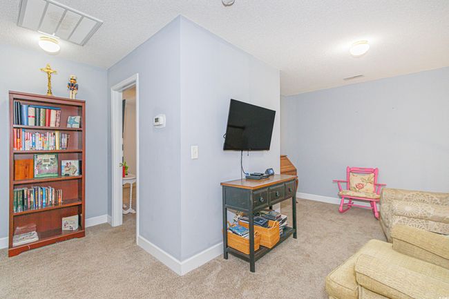 Living area with light colored carpet and a textured ceiling | Image 13