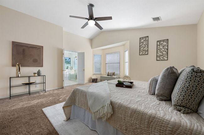 Bedroom featuring carpet, a ceiling fan, vaulted ceiling, visible vents, and baseboards | Image 23