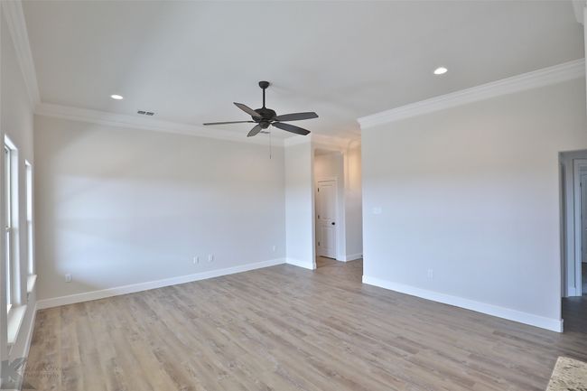 Spare room featuring ornamental molding, ceiling fan, light wood-style flooring, and recessed lighting | Image 8