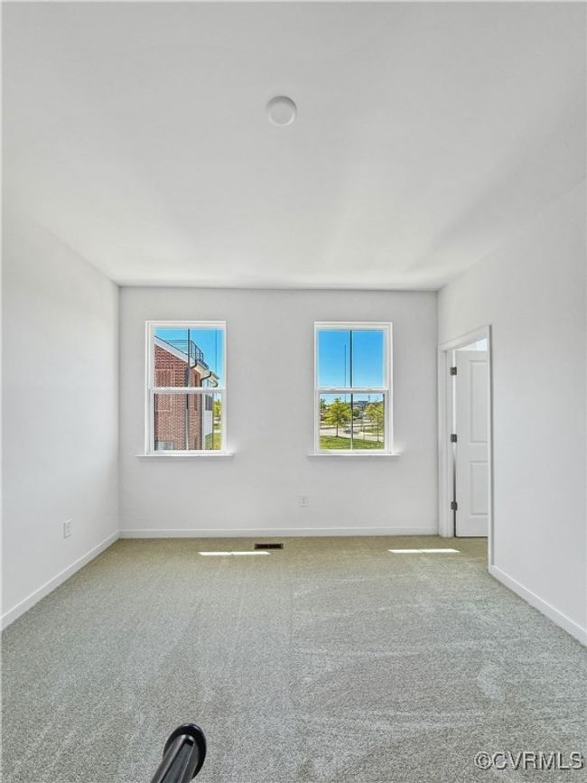 Carpeted spare room featuring baseboards and visible vents | Image 12