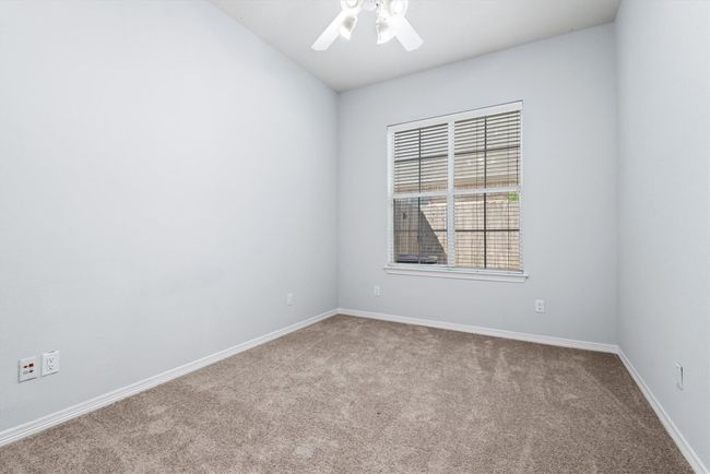 The spacious secondary bedroom offers a large closet, a ceiling fan and ample light from the large window. | Image 15