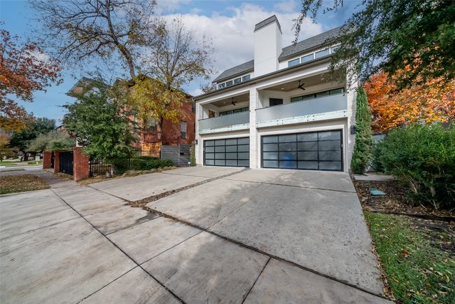 View of home's exterior featuring driveway, a ceiling fan, a garage, a chimney, and a balcony | Image 5