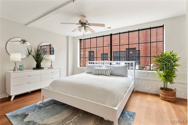 Bedroom with wood finished floors and beamed ceiling | Image 10