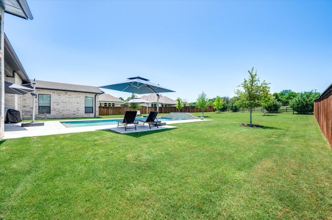 View of yard with a fenced in pool, a fenced backyard, and a patio area | Image 35