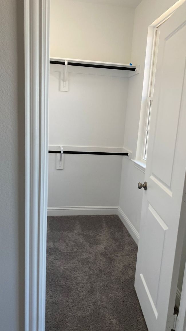 Spacious closet with dark colored carpet | Image 11