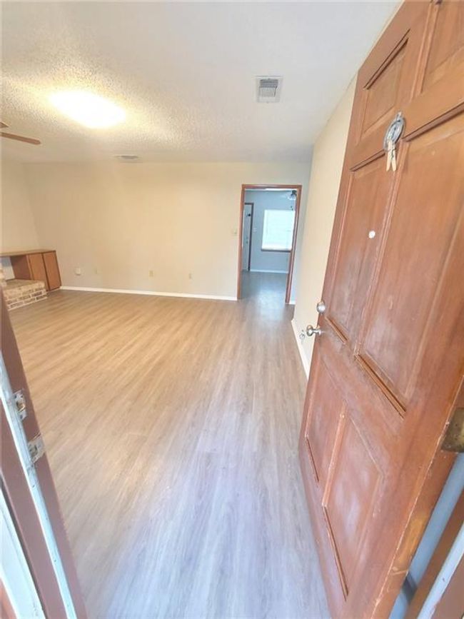 Unfurnished room with light wood-style flooring, a textured ceiling, and a ceiling fan | Image 4