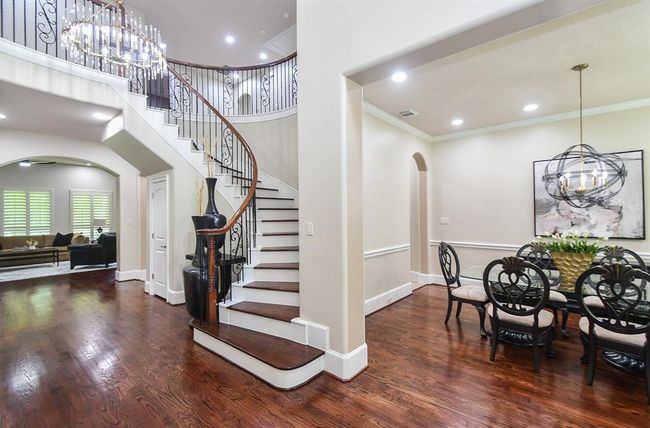 Stylish living space that oozes sophistication.Elegant spiral staircase adorned with stained treads and white risers. Custom wrought iron spindles adds a touch of sophistication this Fairmont home embodies. | Image 7