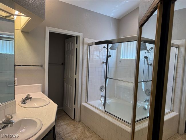 Bathroom featuring healthy amount of natural light, tiled shower / bath combo, and double vanity | Image 9