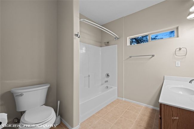 Bathroom with toilet, vanity, tile patterned flooring, and baseboards | Image 19