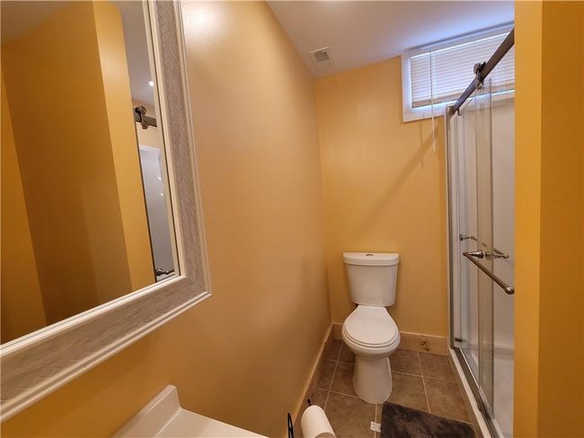 Bathroom featuring tile floors, a shower with door, and toilet | Image 18