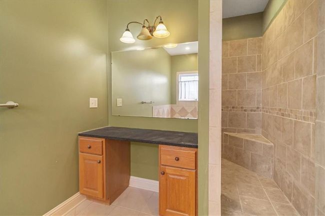 Full bathroom with baseboards, a tile shower, tile patterned flooring, and vanity | Image 31