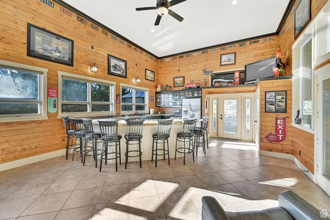 Interior space featuring crown molding, light tile patterned floors, wooden walls, and ceiling fan | Image 41