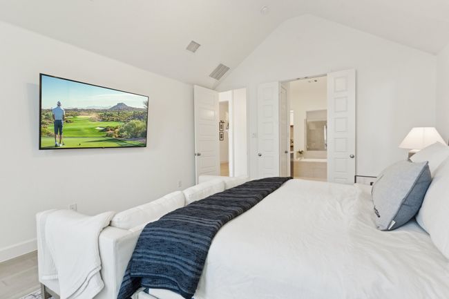 Bedroom featuring vaulted ceiling, connected bathroom, light wood-style flooring, and baseboards | Image 18