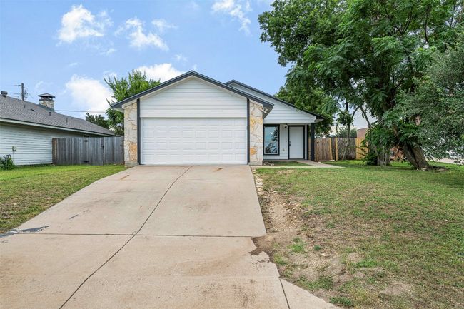 View of front facade with concrete driveway, stone siding, and an attached garage | Image 34